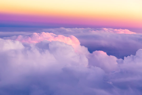 Beautiful sunset sky above clouds with nice dramatic light. View from airplane window