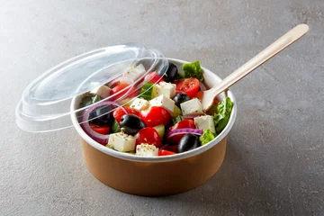 Poster Im Rahmen Greek salad in take away bowl on white background © bigacis