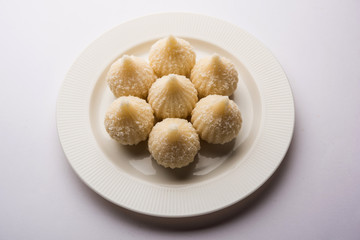 Sweet Modak made using coconut, khoya and sugar. Popular Maharashtrian recipe offered to lord Ganesha in Ganesh Festival. Served in a plate. Selective focus