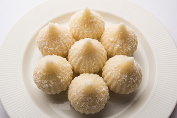 Sweet Modak made using coconut, khoya and sugar. Popular Maharashtrian recipe offered to lord Ganesha in Ganesh Festival. Served in a plate. Selective focus