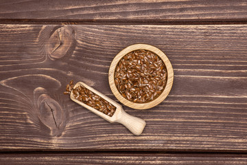 Fresh brown flaxseeds on brown wood