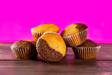 Group of five whole fresh baked marble muffin with pink in background
