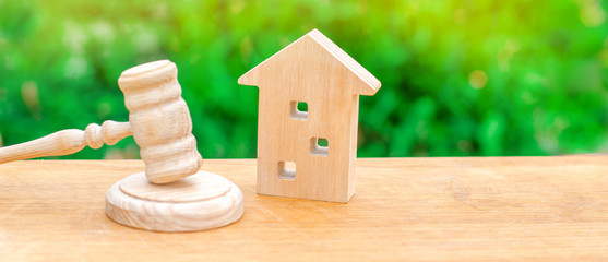 A miniature wooden house and a hammer of the judge. Auction to buy / sell a house. Forced eviction and confiscation. Clarification of ownership of property. Concept settlement of litigation. Court