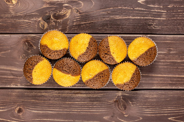 Group of eight whole fresh baked marble muffin flatlay on brown wood