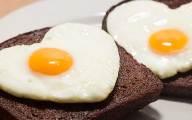 Two Slices of Bread with Fried Eggs in the Shape of Heart on the
