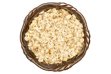 Lot of whole flat raw rolled oats in old iron bowl flatlay isolated on white background