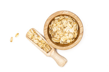 Lot of whole flat raw rolled oats in a scoop with wooden bowl flatlay isolated on white background
