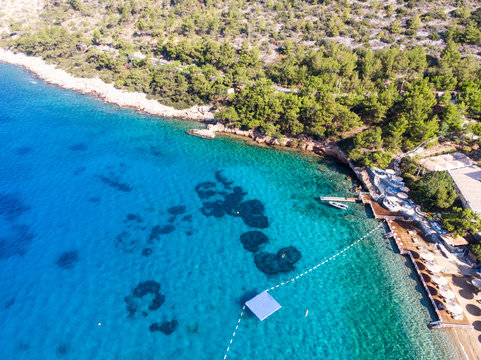 Aerial View of Beach Cove with Sunbeds, Blue Turquoise Sea and Trees
