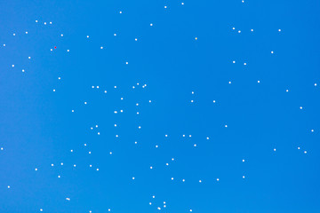 White balls flying in the blue sky
