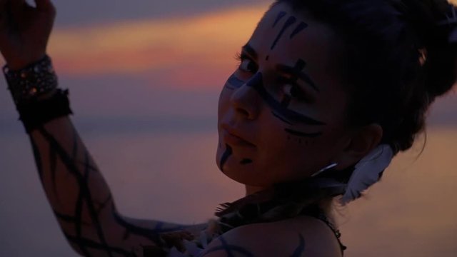 Woman near the river is dancing with fire bowls