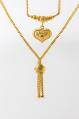 Golden heart pendant isolated on white, golden bind necklace on white,