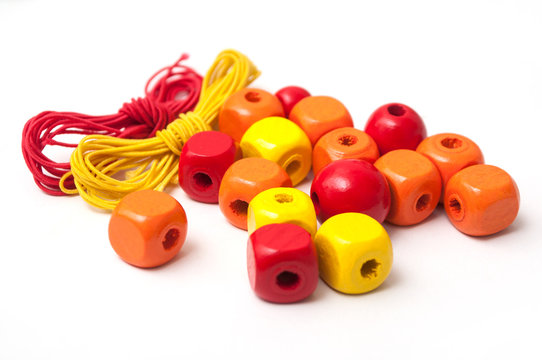 closeup of orange wooden beads on white background