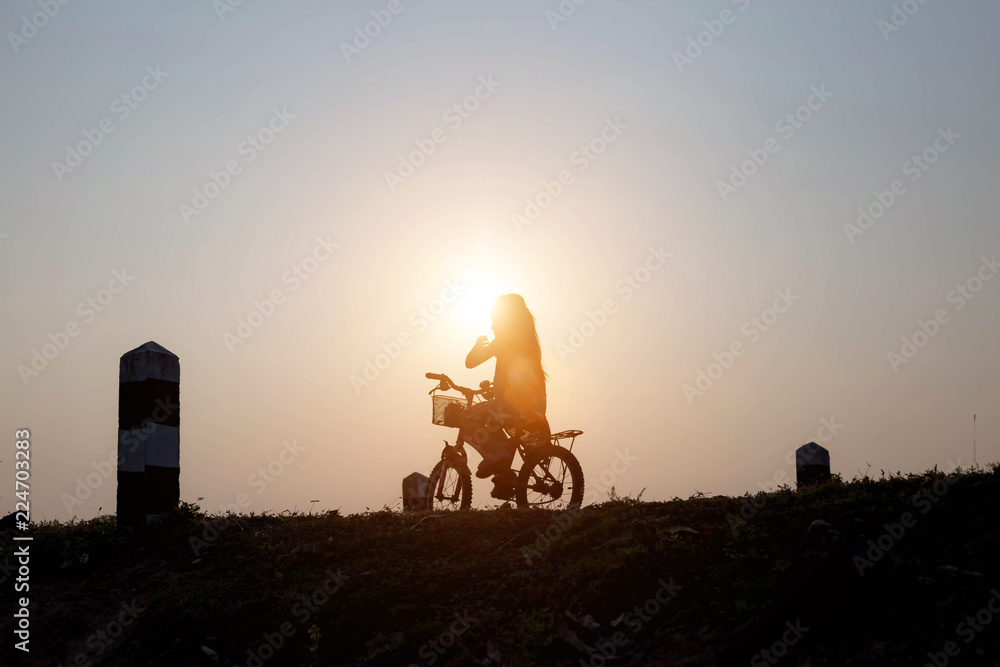 Wall mural young family go for a cycle ride on the beach at background sunset