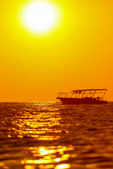 Boat on the sea in the rays of sunset