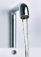 Water flowing from a modern metal tap