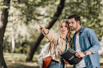 portrait of couple of tourists with map in park