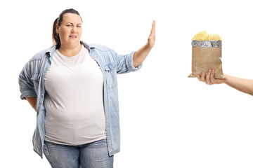 Overweight woman refusing to eat bag of potato chip