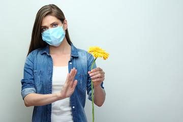 Stop allergy concept with woman holding yellow flower.