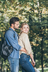 Fototapeta premium side view of romantic couple standing in autumn park