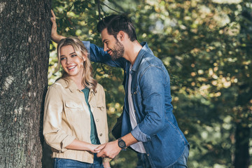 happy romantic couple holding hands in autumn park