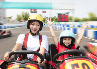 mother and daughter driving go kart on the track