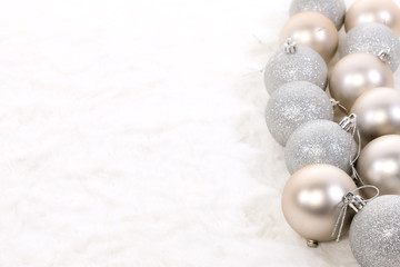 festive Christmas ornamental decorations on a luxurious white fur background with space for copy