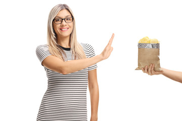 Young woman refusing a bag of potato chips