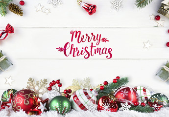 Greeting Festive Christmas composition of green and red balls on white wooden boards in frame fir...