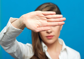 Woman showing stop symbol with outstratched hand and closed eyes