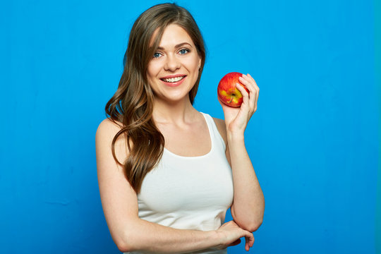 Smiling woman holding red apple. Toothy smile.