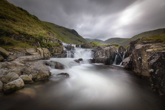 Dark and moody overcast over waterfall with long exposure Lake District England