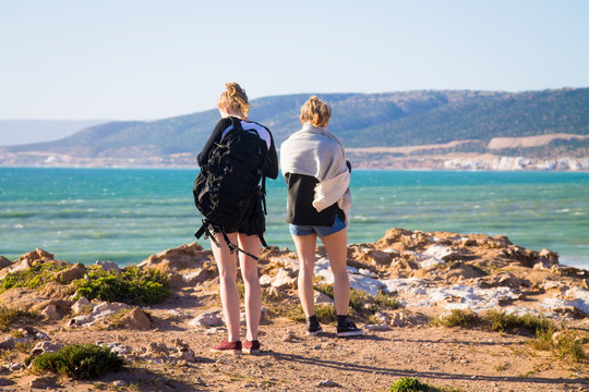 Two girls on a rock against the background of the ocean. The coast of the Atlantic Ocean. The beach is near Agadir. Africa Morocco