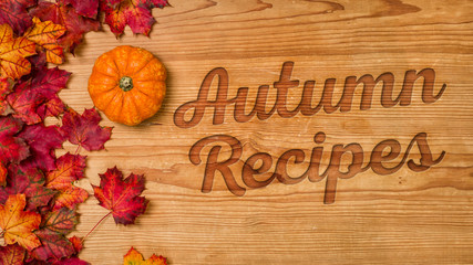 A wooden background with autumn foliage - Autumn Recipes
