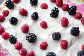 Cake with whipped white cream, fresh blueberries, blackberry and raspberry Close up.