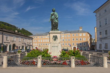 Obraz premium Pomnik Wolfganga Amadeusza Mozarta na placu Mozartplatz w Salzburgu w Austrii.