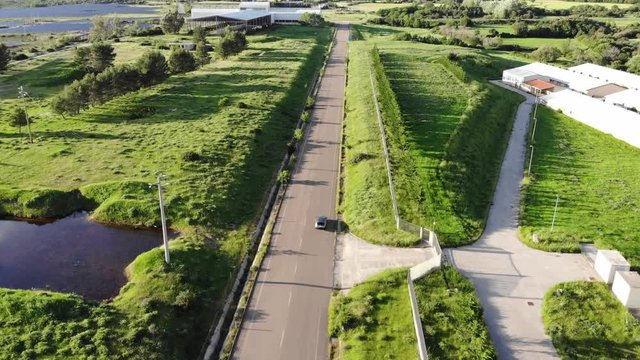 Car chase aerial view on beautiful road with green field