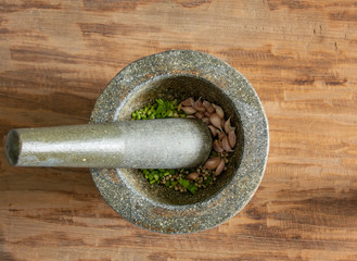 stone mortar with peppercorn and garlic on wood background