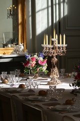 Chandelier et bouquet de fleurs sur une table dressée pour un repas de gala