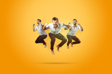 Fototapeta na wymiar Creative background. Young, handsome man, jumping for joy, very much happy, yellow background. The concept of altero, joy, celebration.