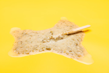 studio shoot of green bean popsicle melted on yellow background