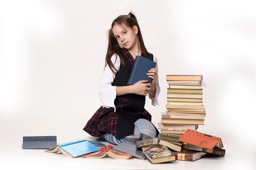 Girl schoolgirl with a big pile of books