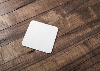 Blank square beer coaster on wooden background. - obrazy, fototapety, plakaty