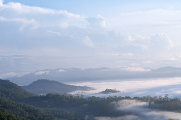Mountain range with visible silhouettes through the morning colorful fog.