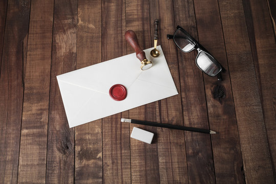 Blank envelope and stationery on wooden background.