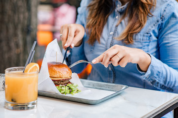 Eating delicious fast food with a fork and a knife.