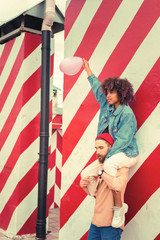 Peaceful mood. Calm strong young man carefully holding his beloved woman on the shoulders and standing with his eyes closed