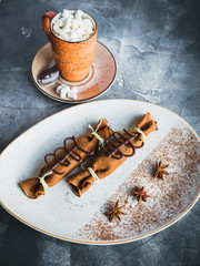Chocolate pancake with cinnamon, anise and cup of coffee with marshmallow. Dessert and coffee