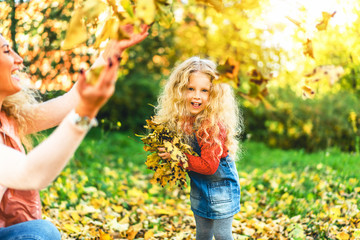 Mother with her little daughter have fun in the park.