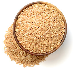 uncooked oats in the wooden bowl, isolated on white, top view