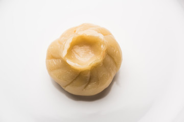 Dumpling momos food from Nepal or Ladakh served with red chilli chutney over moody background. Selective focus